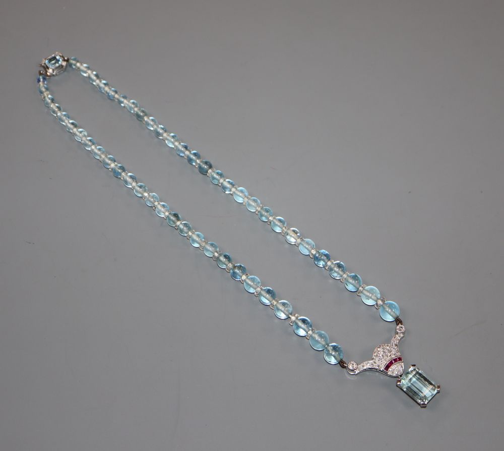 A 20th mid to late 20th century white metal, aquamarine, ruby and diamond set drop pendant on bead necklace.